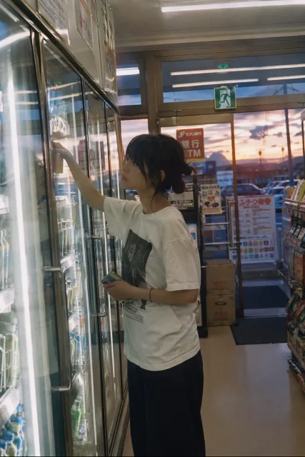 飲み物を選ぶ人物を日本のネガフィルム風に写すプロンプト